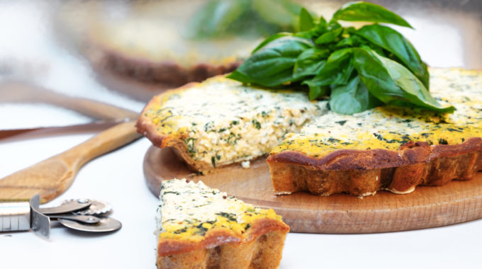 Homemade cake with short bark beetroot with tofu and spinach decorated with basil leaves. on a white background