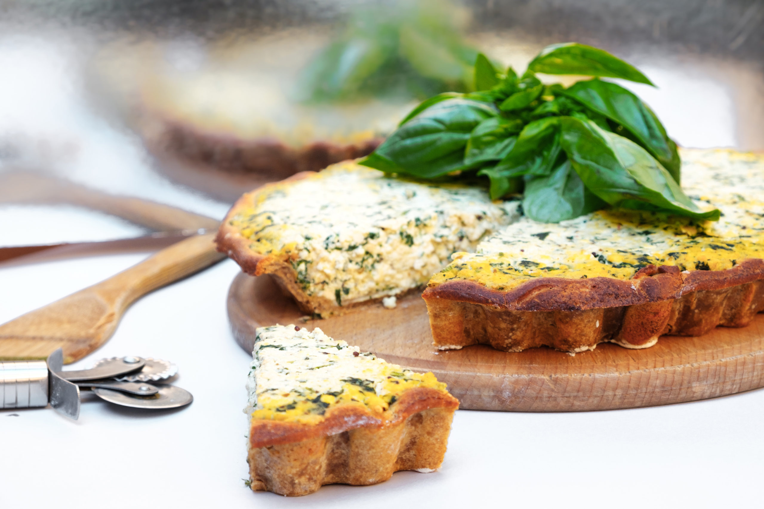 Homemade cake with short bark beetroot with tofu and spinach decorated with basil leaves. on a white background